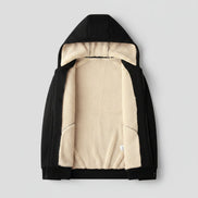Black jacket with beige fleece lining on a beige textured background