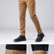 Brown corduroy pants worn by a person on a dark background
