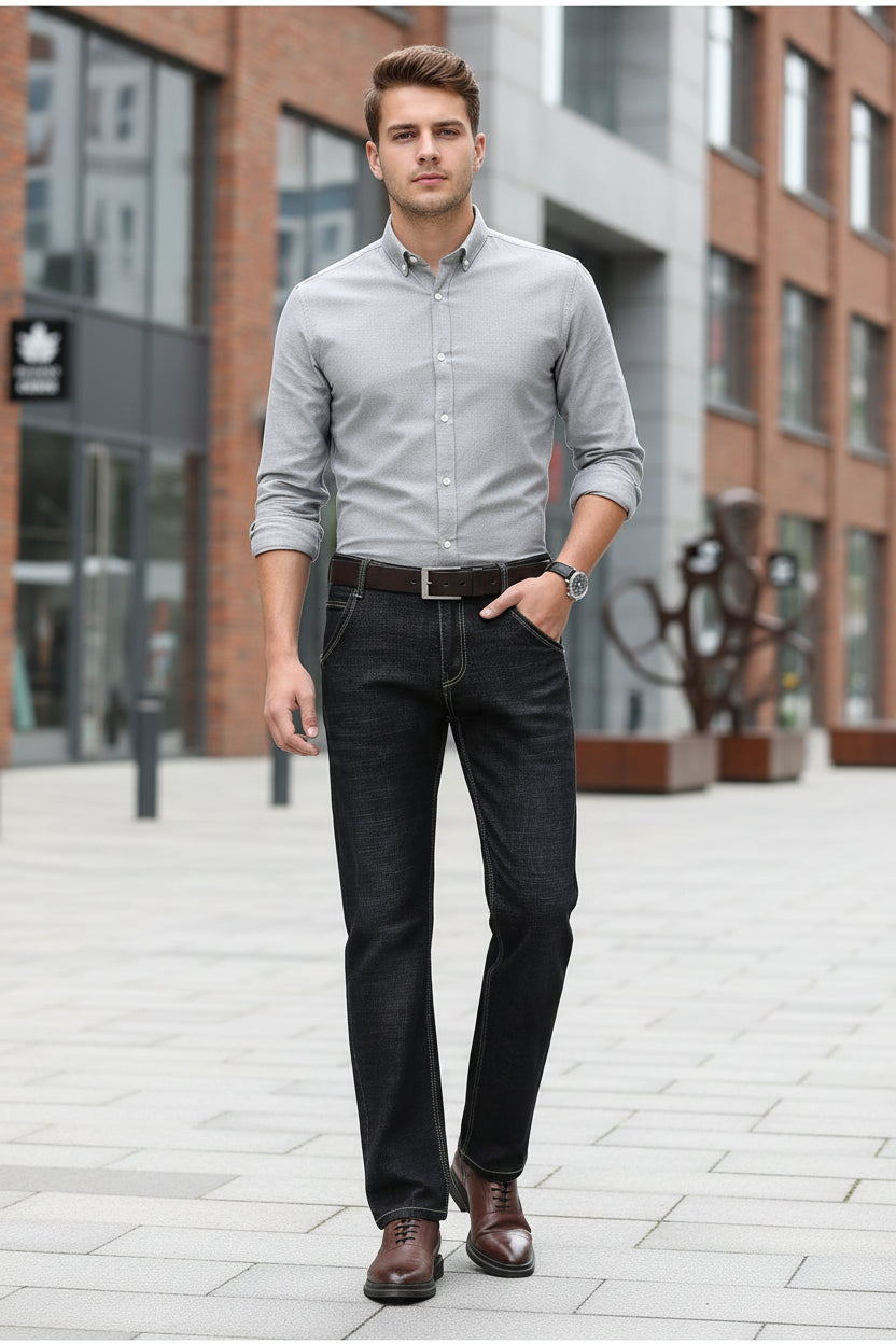 Person wearing dark jeans and brown shoes on a gray background