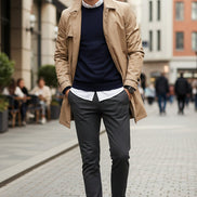 Black loafers on a gray surface with a hand holding one shoe.