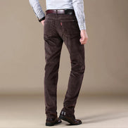 Brown corduroy pants worn by a person on a beige background