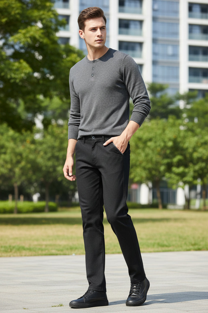 Black men's trousers worn by a person on a gray background