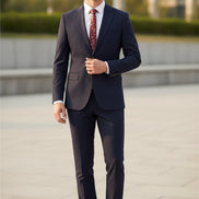 Black suit with a red patterned tie on a mannequin, paired with brown shoes on a white background.