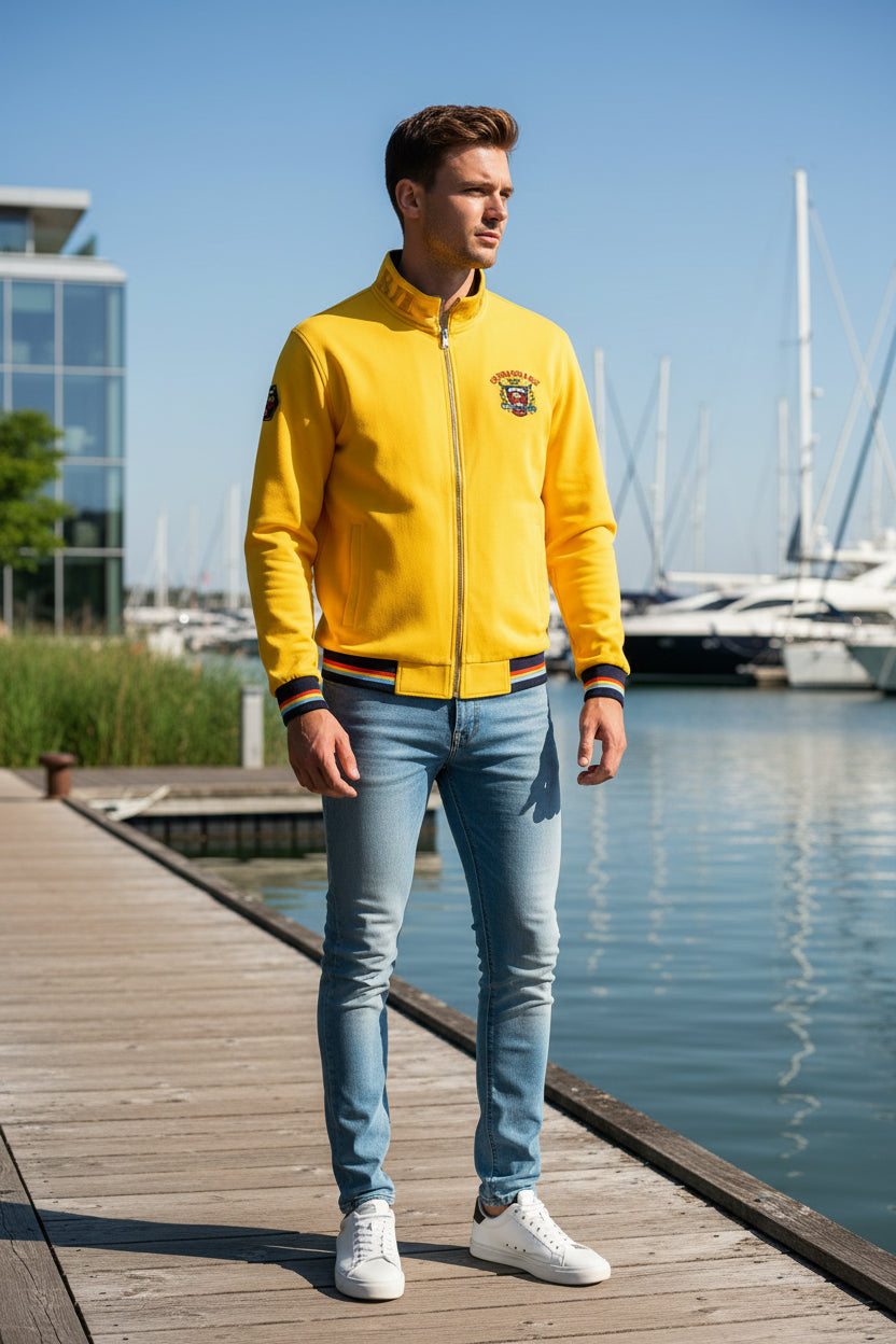 A bright yellow zip-up jacket with a stand collar, featuring a 'Cumberland' crest on the left chest, 'Royal York' text on the right sleeve, and striped ribbed cuffs and hem.