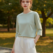 Person wearing a light green shirt with a neutral background