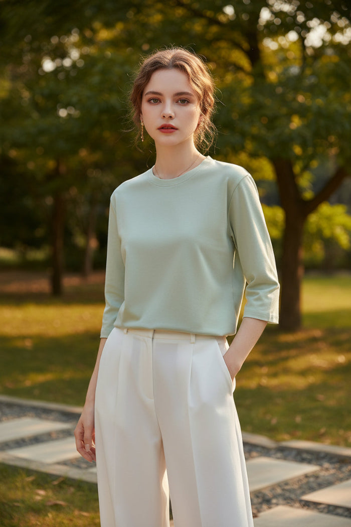 Person wearing a light green shirt with a neutral background