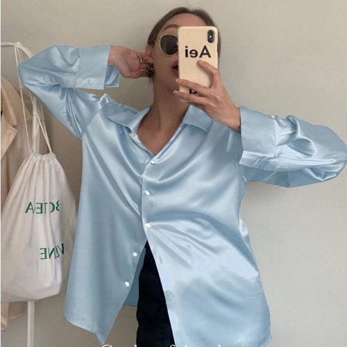 Light blue satin button-down shirt worn by a model taking a mirror selfie.