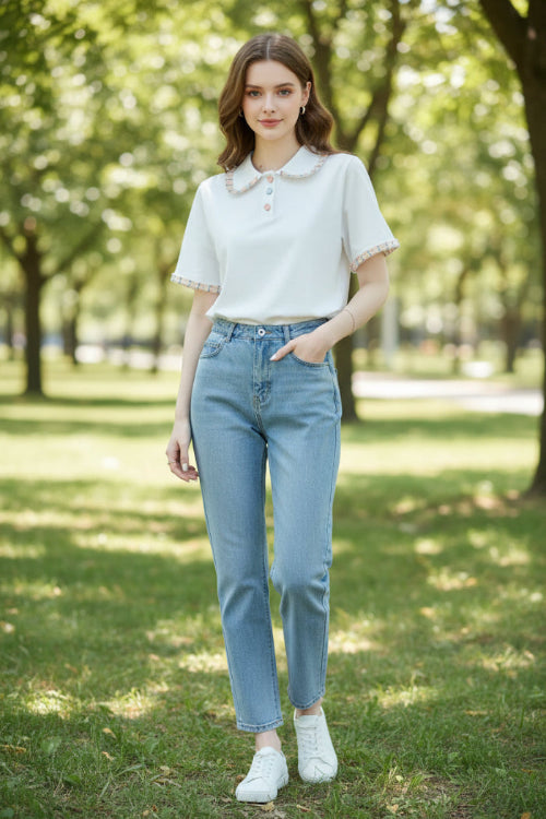 A woman wearing a white short-sleeve polo shirt with a decorative pastel floral collar and matching ruffled sleeve cuffs, 