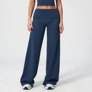 Person wearing navy blue athletic pants and top on a white background