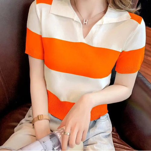 A woman wearing a short-sleeve knit polo shirt with bold horizontal orange and off-white stripes, 