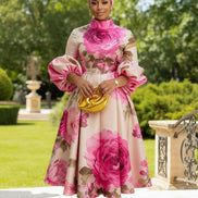 Woman in a floral dress holding a yellow clutch in a living room.