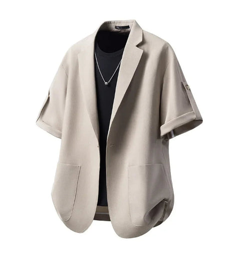 A light beige short-sleeve blazer with wide lapels and front patch pockets, styled open over a black t-shirt on a white background.