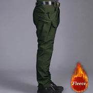 Side view of a model wearing dark olive green cargo pants with a zippered thigh pocket, flap pocket, black belt, and black shoes, alongside a fleece label graphic against a gray background.