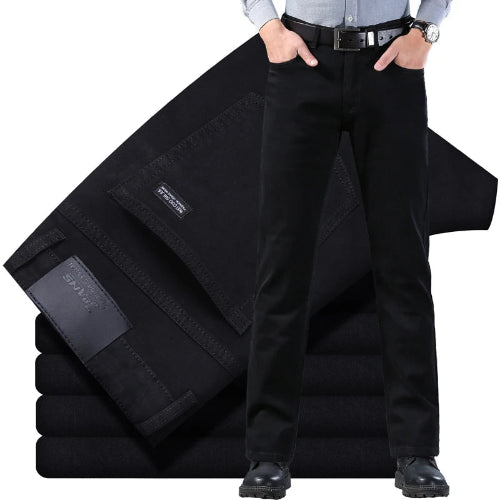 Person wearing black pants with a folded black jacket on a white background