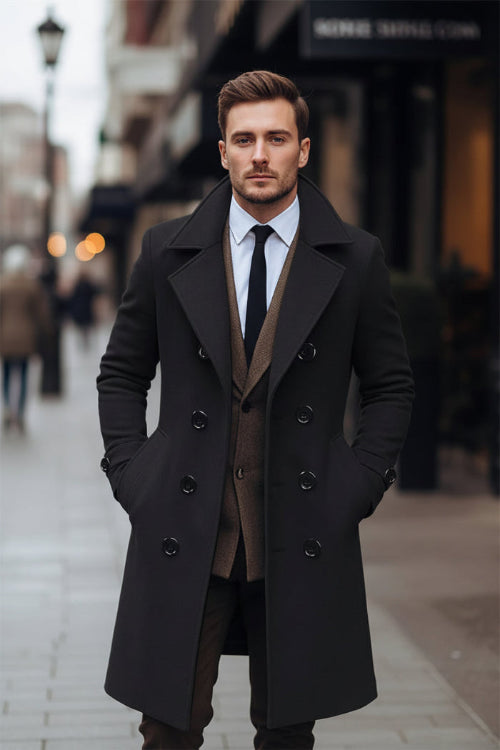 Man wearing a dark coat and brown vest on a city street
