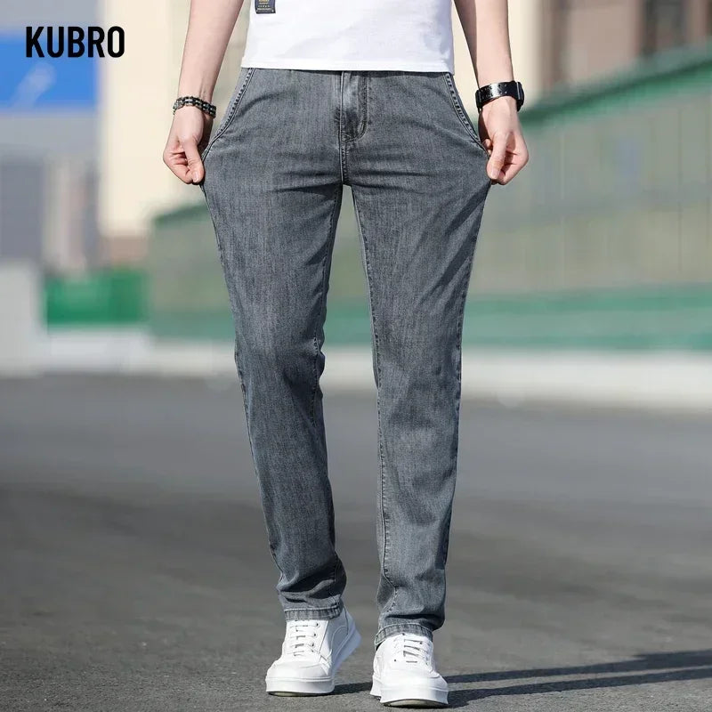 Person wearing gray jeans and white sneakers with 'KUBRO' branding.