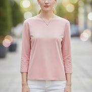 Person wearing a pink long-sleeve top with a neutral background