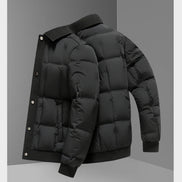 A black puffer jacket with horizontal quilting, ribbed knit collar, cuffs, and hem, shown from a three-quarters angle against a gray studio background.
