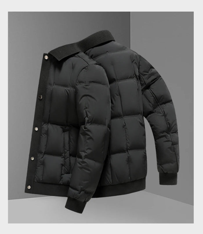 A black puffer jacket with horizontal quilting, ribbed knit collar, cuffs, and hem, shown from a three-quarters angle against a gray studio background.