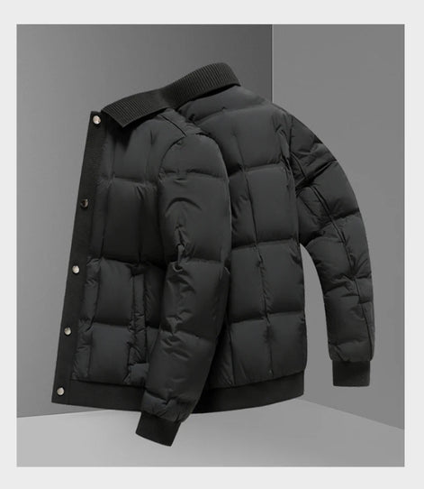 A black puffer jacket with horizontal quilting, ribbed knit collar, cuffs, and hem, shown from a three-quarters angle against a gray studio background.