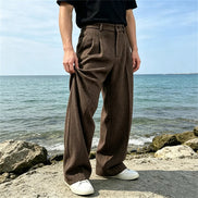Brown wide-leg pants worn by a man by the sea