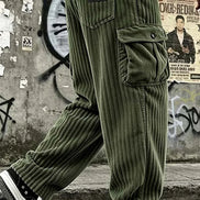 Olive green corduroy cargo pants worn by a model, featuring a ribbed corduroy texture, a large front flap pocket, and a black brand patch on the back pocket