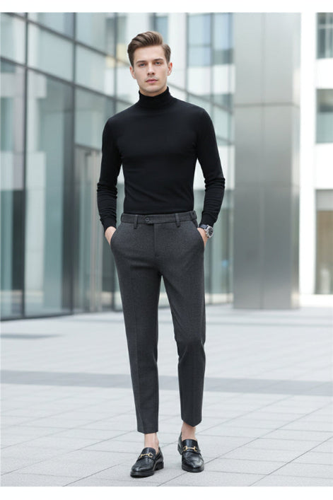 A person wearing dark gray textured slim-fit trousers, paired with a black long-sleeve top and black loafers, 