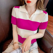 A woman wearing a short-sleeve knit polo shirt with bold horizontal stripes in white and bright magenta pink, seated on a dark brown leather chair.