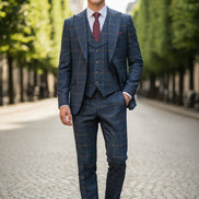 Blue checkered suit on a mannequin with a red tie against a beige curtain background