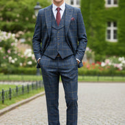 Blue checkered suit on a mannequin with a red tie against a beige curtain background