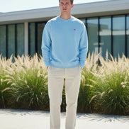 Light blue sweatshirt with a small red logo on a white background