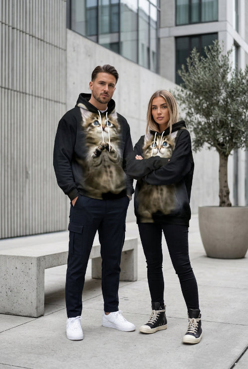 A black pullover hoodie featuring a large, realistic 3D-printed graphic of a fluffy brown tabby kitten with blue eyes on the front, 