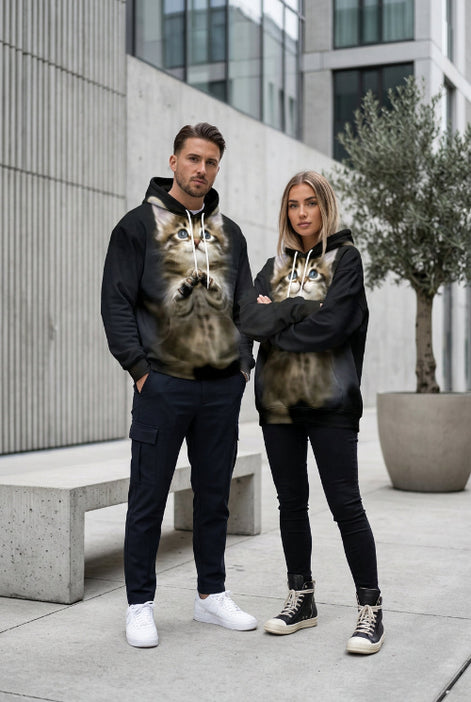 A black pullover hoodie featuring a large, realistic 3D-printed graphic of a fluffy brown tabby kitten with blue eyes on the front, 
