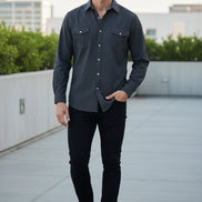 Man standing on a rooftop with a cityscape in the background