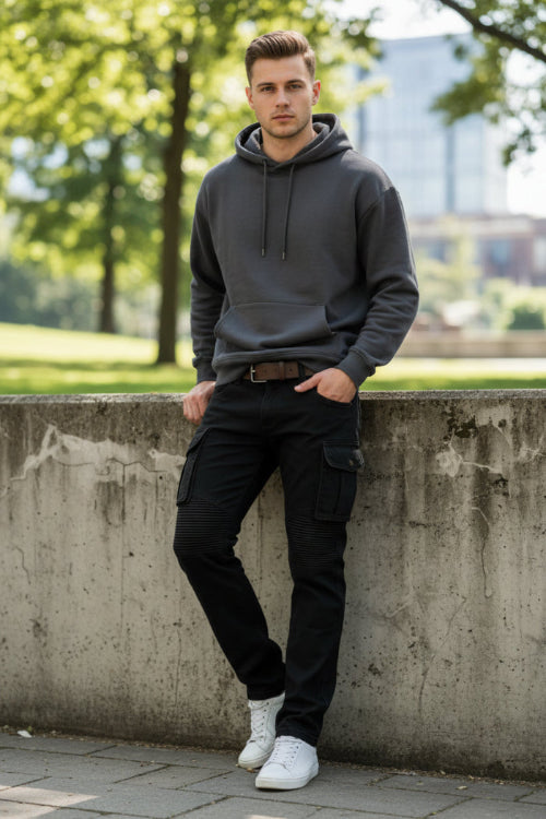 Black cargo motorcycle pants with ribbed knee panels and a brown leather belt, shown against a textured dark gray background.