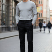 Folded black pants with a brand logo on a gray surface