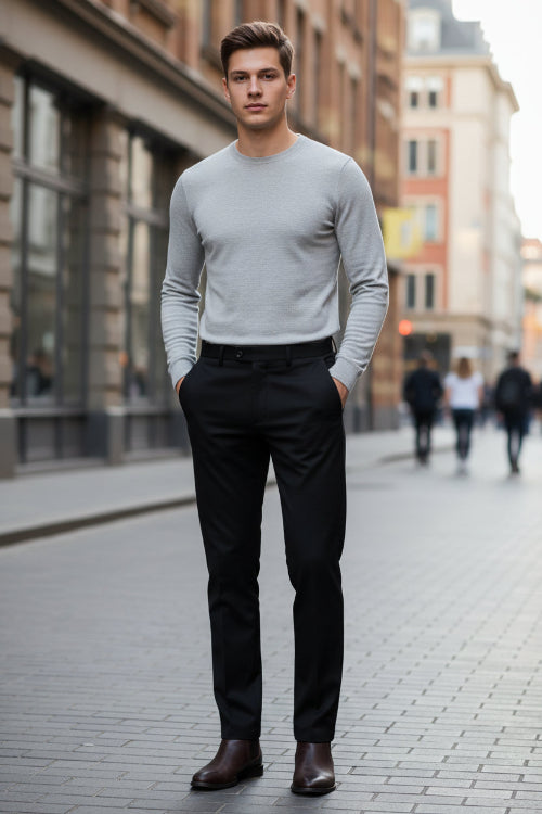 Folded black pants with a brand logo on a gray surface