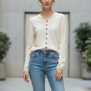 Beige cardigan worn by a person in a clothing store setting