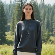 Person wearing a gray sweater with a blurred background