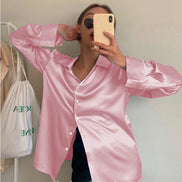 Pink satin button-down shirt worn by a model taking a mirror selfie.