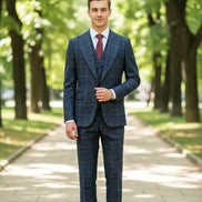 Blue checkered suit with red tie on a mannequin against a brown curtain background