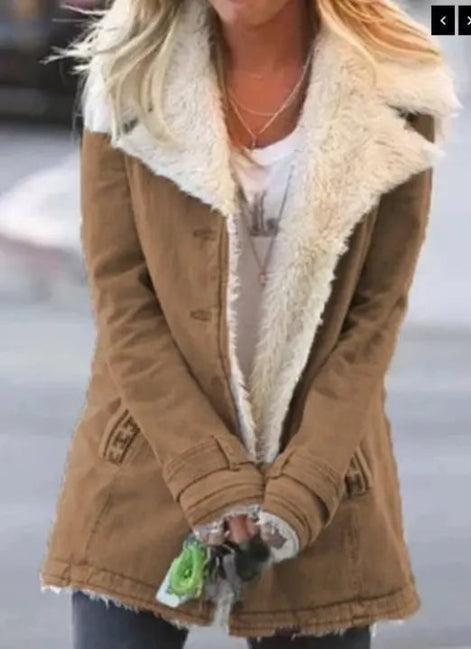 Woman outdoors wearing a tan coat with wide cream fleece-look lapels, front pockets and cuff tabs over a white top