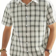 Man wearing a plaid shirt with a white collar on a plain background