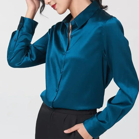 Teal silk shirt worn by a model posing with one hand in a pocket.