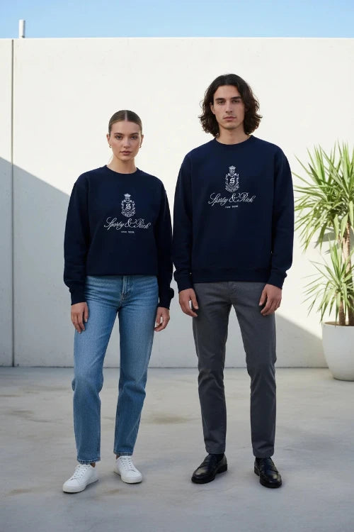 Person wearing a navy blue sweatshirt with a logo and text on a white background