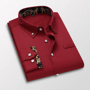 Folded red dress shirt with decorative cuffs on a light gray background