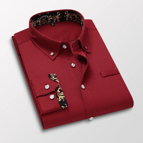 Folded red dress shirt with decorative cuffs on a light gray background