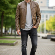 Brown leather jacket worn by a person on a white background