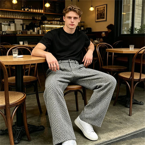 Gray herringbone wide-leg pants worn by a man at a cafe