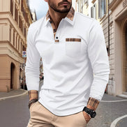 Man wearing a white long-sleeve shirt with plaid accents on a city street.